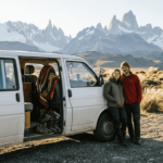 Una pareja disfruta del amanecer junto a su furgoneta en la Patagonia.