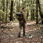 Un senderista atraviesa el bosque llevando solo lo imprescindible en su mochila.
